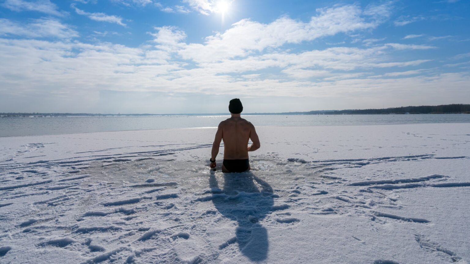 Man taking a cold plunge in an icy lake